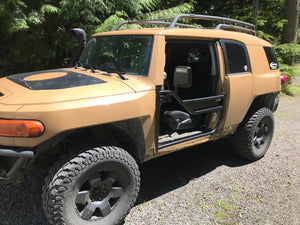 Tan FJ Cruiser with black Metal Tech tube doors installed, shown from front passenger side outdoors.