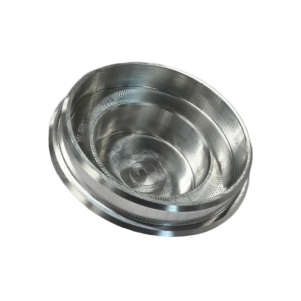 Close-up of a CNC milled billet metal pivot cap with concentric circular grooves and a smooth finish.