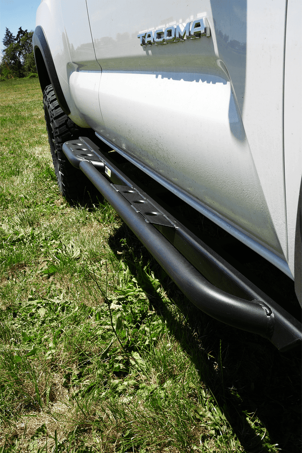 Close-up of black Metal Tech 4x4 side slider installed on white 2016 Toyota Tacoma Access Cab 1.5-door truck.