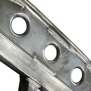 Close-up of metal rock slider section showing welds and circular cutouts on steel plate.