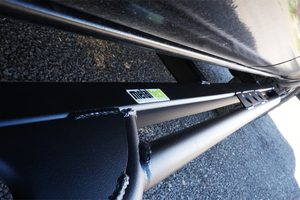 Close-up of black Metal Tech rock slider installed on 2016 Tacoma 4-door long bed, showing weld details and logo.