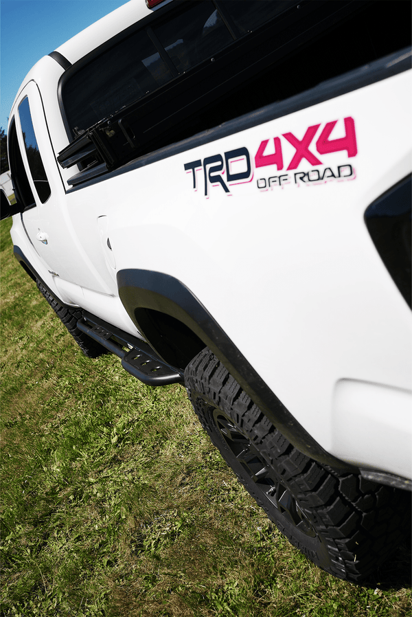 Close-up of black Metal Tech 4x4 side slider installed on white 2016 Toyota Tacoma Access Cab truck.