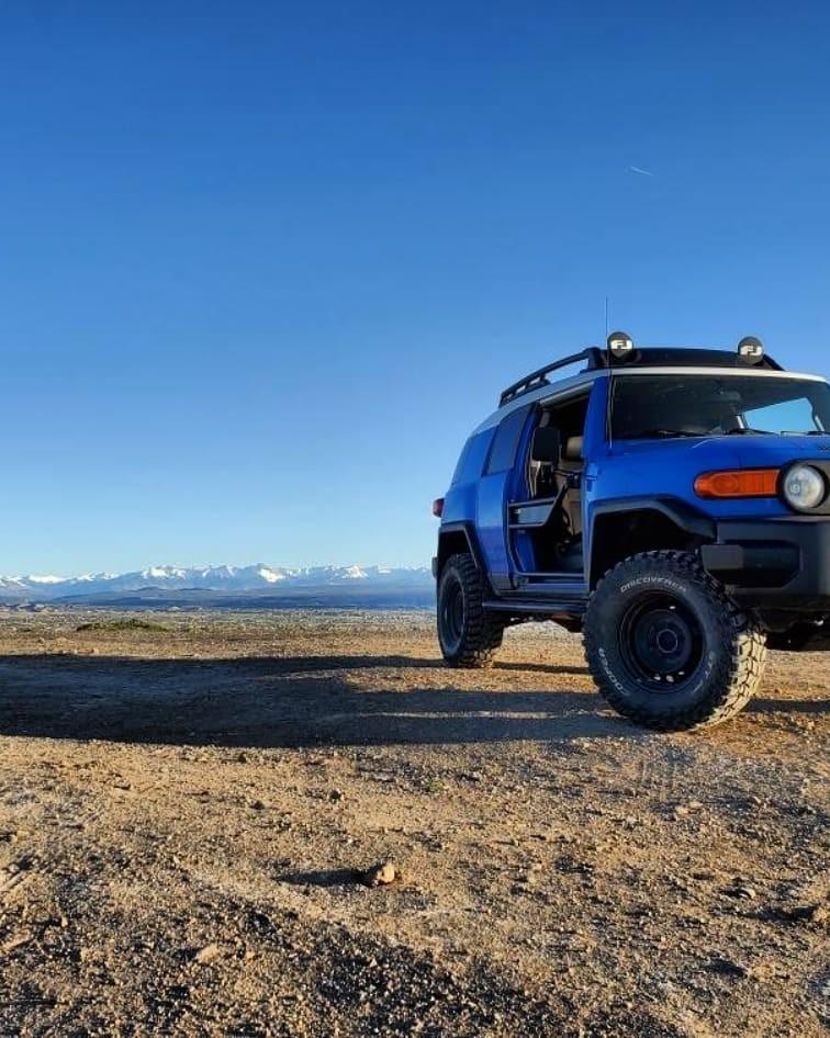 Close-up of orange FJ Cruiser with Metal Tech black tube door and mesh panel installed on driver side.