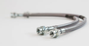 Close-up of two metal extended rear brake lines with threaded fittings for Lexus GX470 and GX460.