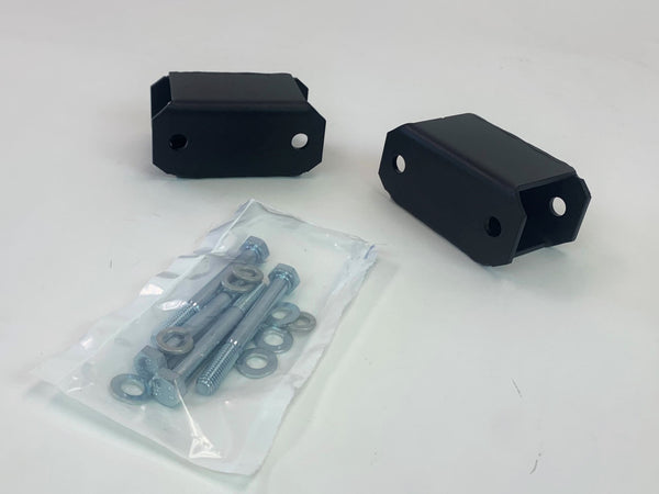 Two black metal sway bar drop brackets with mounting bolts and washers in a plastic bag on a white surface.