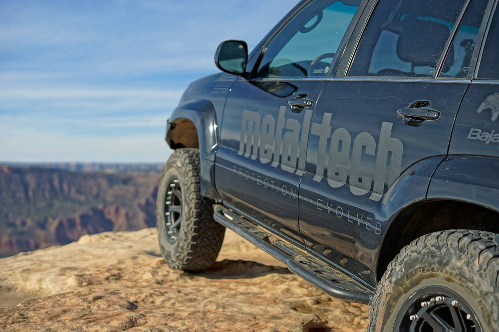 Pair of black steel rock sliders with mounting brackets for Lexus GX470 off-road protection.