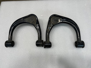 Pair of black upper control arms for GX470, GX460, FJ Cruiser, and 4th-5th gen 4Runner on white background.