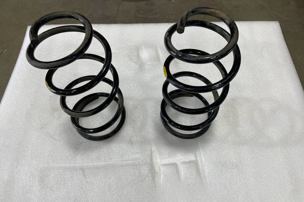 Pair of black rear coil springs for GX470, GX460, FJ Cruiser, and 4Runner on white background.