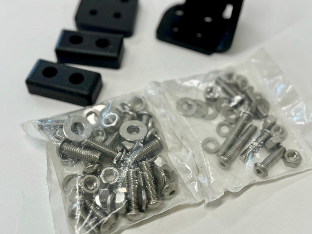 Black left side latch components and hardware for landing pad system on white surface.