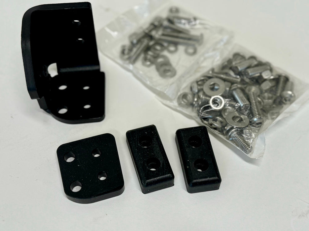 Black left side latch components and hardware for landing pad system on white surface.