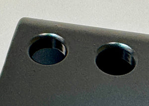 Close-up of black metal rear bump stop drop bracket with two circular mounting holes for Lexus GX470/GX460 long travel suspension.