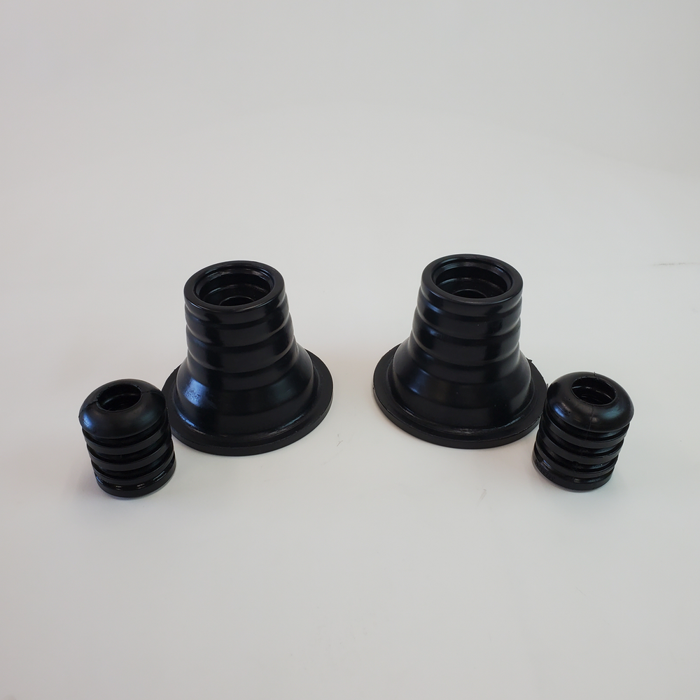 Pair of black rubber rear spring upper isolators with stepped cone design for 4x4 suspension systems.