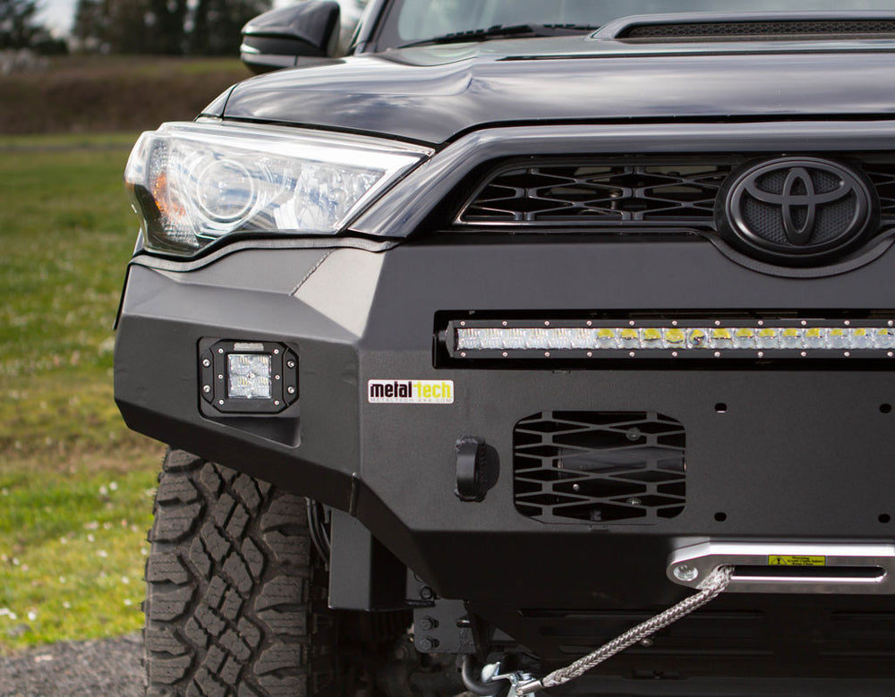 Pair of black metal tech winch hole covers with geometric cutouts for Fortress bumper, shown flat on white background.