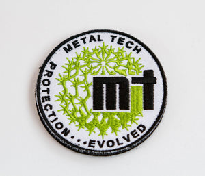 Round Metal Tech 4x4 morale patch with green and black embroidery on white background.