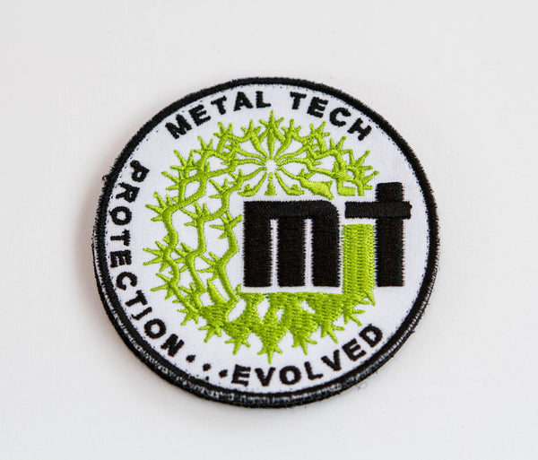 Round Metal Tech 4x4 morale patch with green and black embroidery on white background.