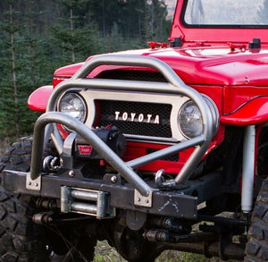 Close-up of red Toyota FJ40 Land Cruiser front with installed Metal Tech stinger bumper and winch.