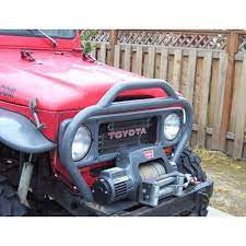 Close-up of red Toyota Land Cruiser front with Metal Tech FJ40 nose guard and mounted winch.