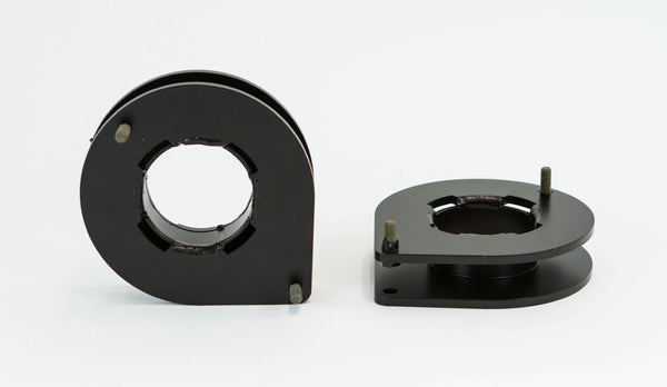 Pair of black metal front spacer plates with mounting hardware, designed for FZJ80 suspension lift.