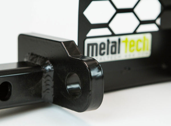 Close-up of black metal winch mount bracket with welded joint and Metal Tech logo on backing plate.