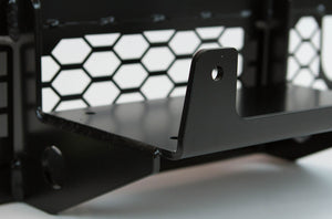 Close-up of black metal winch mount bracket with hex-patterned backing, designed for FJ Cruiser front tube bumper.