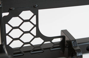 Close-up of black metal winch mount with hexagonal cutouts for FJ Cruiser front tube bumper installation.