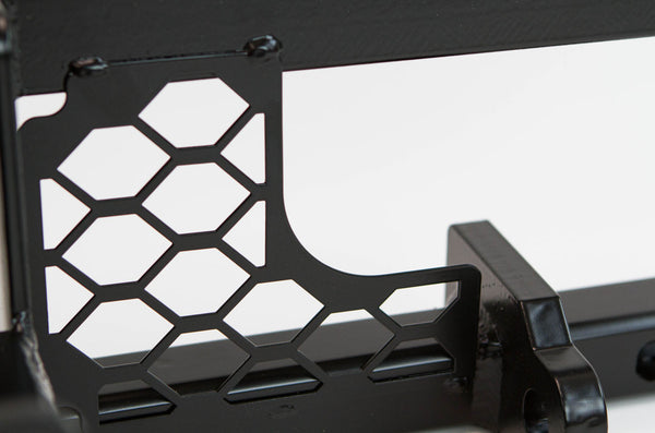 Close-up of black metal winch mount with hexagonal cutouts for FJ Cruiser front tube bumper installation.