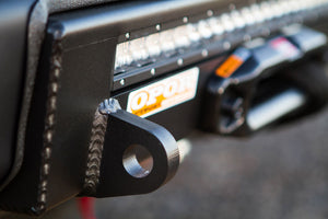 Close-up of black welded steel mounting bracket on 2016 Tacoma Stronghold winch bumper with LED light bar.