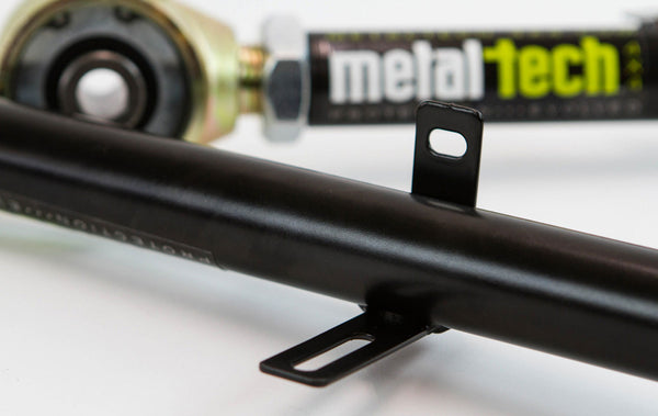 Close-up of black Metal Tech rear upper link with mounting brackets for 100 Series Land Cruiser LX470 suspension.