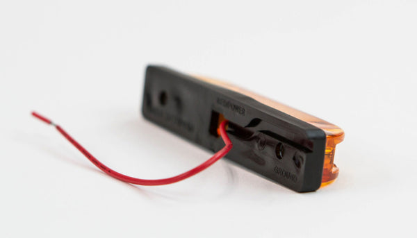 Close-up of amber LED step light for GX470/GX460 rear bumper with red power wire exposed.
