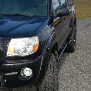 Close-up of black 2005-15 Tacoma with Metal Tech rock sliders installed on the side step area.