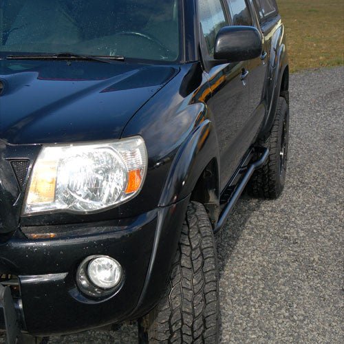 Close-up of black 2005-15 Tacoma with Metal Tech rock sliders installed on the side step area.