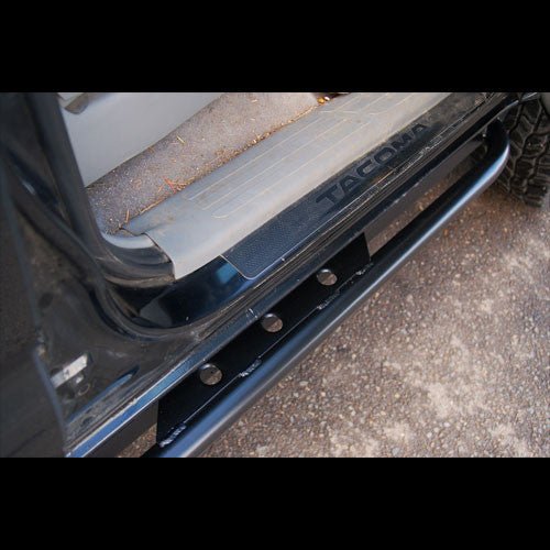 Close-up of black Metal Tech rock slider installed on 2005-2015 Toyota Tacoma side step area.