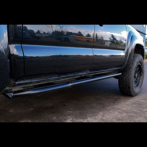 Black metal rock slider installed on the side of a black 2005-15 Toyota Tacoma truck.