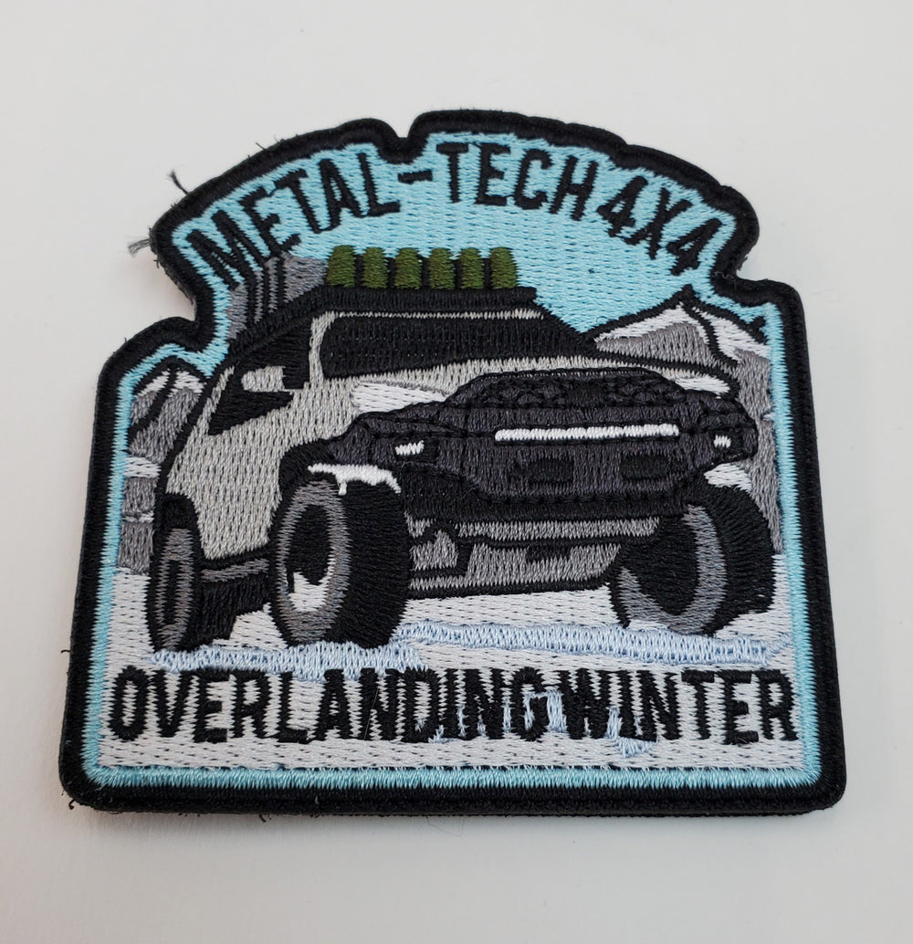 Embroidered patch showing a 4x4 truck in snowy mountains with "Metal-Tech 4x4 Overlanding Winter" text.