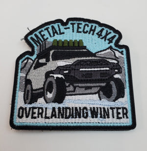 Embroidered patch showing a 4x4 truck in snowy mountains with "Metal-Tech 4x4 Overlanding Winter" text.