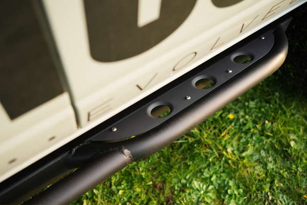 Close-up of black Sidewinder rock slider installed on 2021 Bronco 4-door, showing mounting and textured finish.