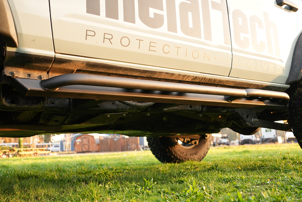 Close-up of black Sidewinder rock sliders installed on the lower side of a 2021 Bronco 4-door.