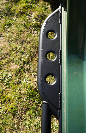 Close-up of black powder-coated Sidewinder RRR rock slider mounted on green 2021 Ford Bronco 2-door, showing weld details.