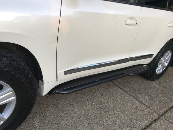 Black Metal Tech 200 Series rock sliders installed on white 2008-2021 Toyota Land Cruiser side, showing full length and mounting.
