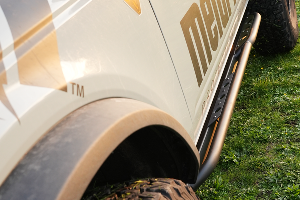 Close-up of black Sidewinder rock slider installed on the side of a beige 2021 Bronco 4-door.