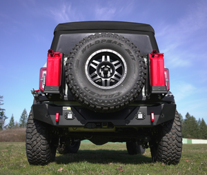 Rear view of Bronco 6G with Metal Tech 4x4 high bumper, spare tire, and red fuel cans mounted on each side.