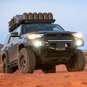 2014-2019 5th Gen 4Runner with Metal Tech Fortress front bumper, winch, and roof rack loaded with gear on rocky terrain.