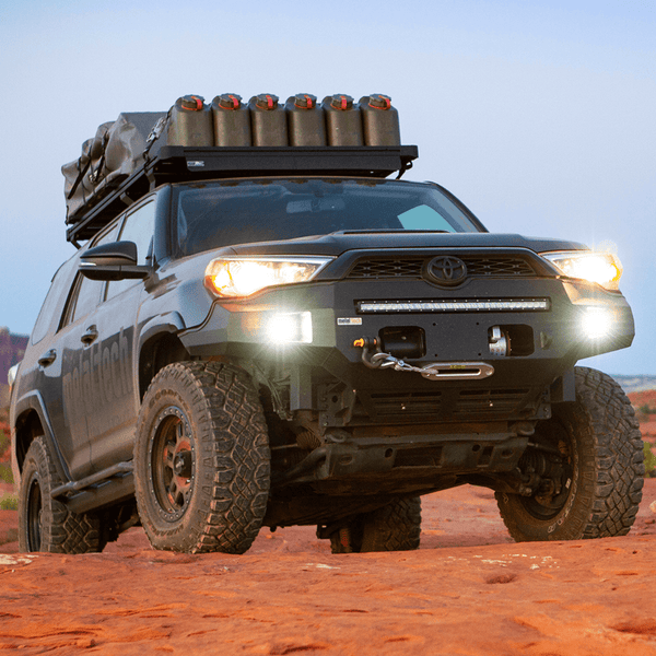 2014-2019 5th Gen 4Runner with Metal Tech Fortress front bumper, winch, and roof rack loaded with gear on rocky terrain.