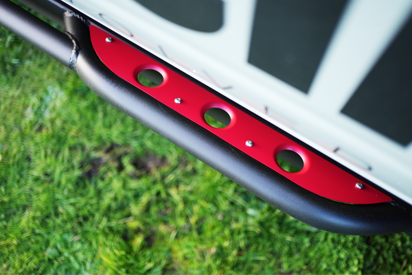 Close-up of black and red Sidewinder rock slider installed on the lower side of a 2021 Bronco 4-door.