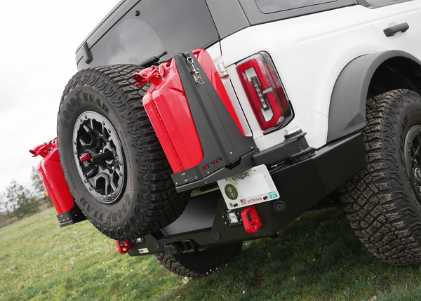 Close-up of Bronco 6G rear high bumper by Metal Tech 4x4 with dual red fuel cans and spare tire mounted.