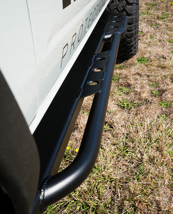 Close-up of black metal rock slider installed on 2021 Ford Bronco 4-door, showing weld details and mounting points.