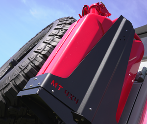Close-up of black Metal Tech 4x4 rear high bumper with red fuel can mounted on Bronco 6G, showing tire and blue sky background.
