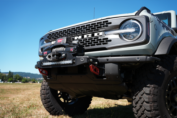 Front view of white Bronco 6G with Stronghold winch mount and winch installed on off-road bumper.