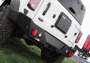 Close-up of black Metal Tech 4x4 Bronco 6G rear Aces High bumper installed on white Ford Bronco with red tow hooks.