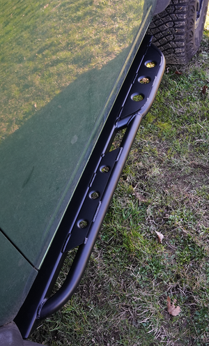 Close-up of black Sidewinder RRR rock slider installed on 2021 Ford Bronco 2-door, showing welds and tire tread.